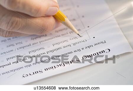Stock Photo - Close-up of hand filling out form. Fotosearch
