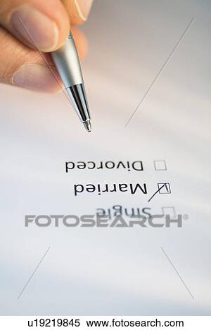 Stock Photography - Close-up of hand filling out form. Fotosearch