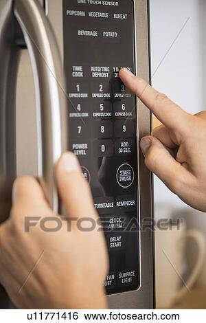 Close-up of hand using microwave oven View Large Photo Image Stock Photograph - Close-up of hand using microwave oven. Fotosearch