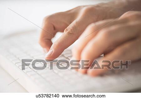 Stock Image - Close-up of hands typing on keyboard. Fotosearch