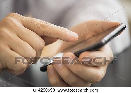 Stock Photo - Close-up of hands using smartphone. Fotosearch