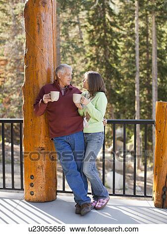 Couple drinking coffee on porch View Large Photo Image Stock Photograph - Couple drinking coffee on porch. Fotosearch