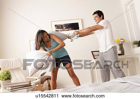 Couple fighting with pillow in bedroom View Large Photo Image Stock Image - Couple fighting with pillow in bedroom. Fotosearch