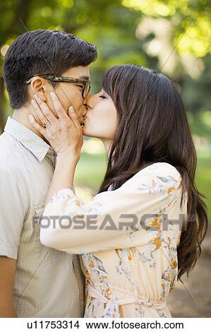 Picture - Couple kissing in park. Fotosearch