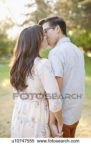 Couple kissing in park View Large Photo Image Stock Photography - Couple kissing in park. Fotosearch