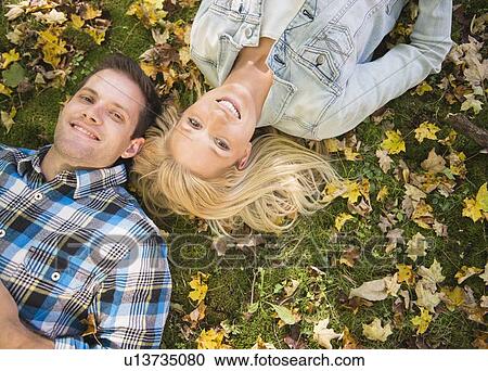 Couple lying on grass View Large Photo Image Stock Image - Couple lying on grass. Fotosearch