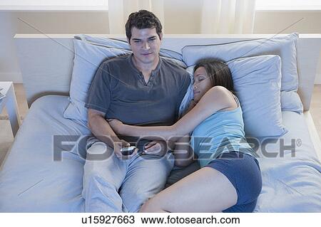 Couple relaxing on bed View Large Photo Image Stock Image - Couple relaxing on bed. Fotosearch