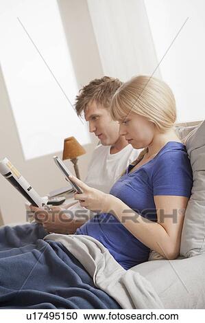 Couple sitting in bed reading View Large Photo Image Stock Image - Couple sitting in bed reading. Fotosearch