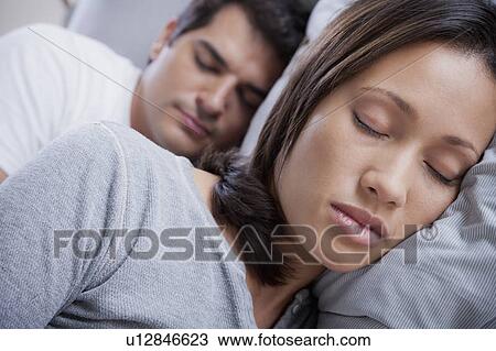 Stock Image - Couple sleeping in bed. Fotosearch