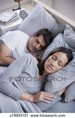 Stock Image - Couple sleeping in bed. Fotosearch