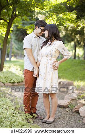 Couple standing in park View Large Photo Image Stock Photograph - Couple standing in park. Fotosearch