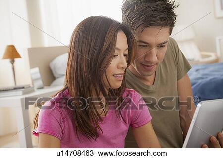 Stock Image - Couple using digital tablet. Fotosearch