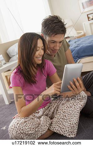 Couple using digital tablet View Large Photo Image Stock Image - Couple using digital tablet. Fotosearch