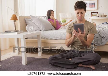 Couple using mobile phone and digital tablet View Large Photo Image Stock Image - Couple using mobile phone and digital tablet. Fotosearch