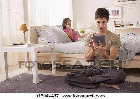Couple using mobile phone and digital tablet View Large Photo Image Stock Photo - Couple using mobile phone and digital tablet. Fotosearch
