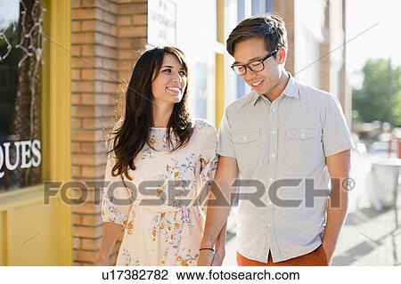 Couple walking on sidewalk View Large Photo Image Stock Image - Couple walking on sidewalk. Fotosearch