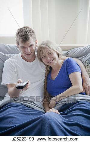 Stock Photo - Couple watching television in bed. Fotosearch
