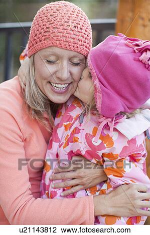 Daughter (4-5) kissing mother outdoors View Large Photo Image Stock Image - Daughter (4-5) kissing mother outdoors. Fotosearch