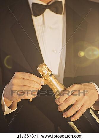 Stock Image - Elegant man opening champagne. Fotosearch