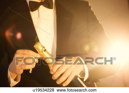 Elegant man opening champagne View Large Photo Image Stock Photo - Elegant man opening champagne. Fotosearch