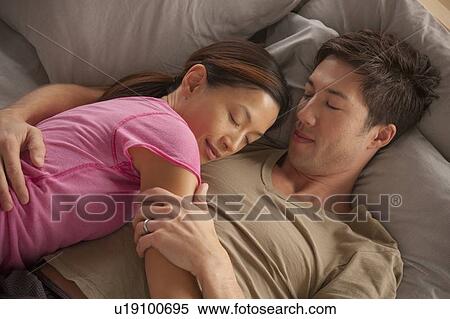 Stock Photography - Elevated view of couple sleeping. Fotosearch