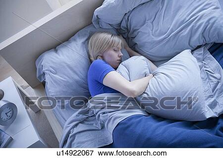 Elevated view of woman sleeping and hugging pillow View Large Photo Image Stock Photo - Elevated view of woman sleeping and hugging pillow. Fotosearch