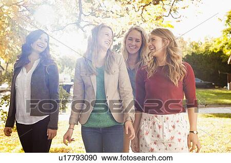 Stock Image - Four friends walking in autumn day. Fotosearch