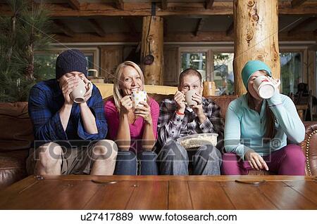 Friends drinking tea in log cabin View Large Photo Image Stock Photo - Friends drinking tea in log cabin. Fotosearch