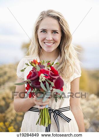 Front view portrait of young woman holding bouquet View Large Photo Image Stock Photo - Front view portrait of young woman holding bouquet. Fotosearch