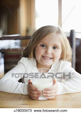 Stock Image - Girl (4-5) drinking milk in kitchen. Fotosearch