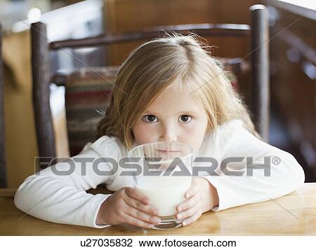 Stock Image - Girl (4-5) drinking milk in kitchen. Fotosearch