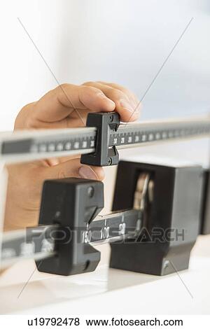 Hand adjusting weight scales View Large Photo Image Stock Photo - Hand adjusting weight scales. Fotosearch