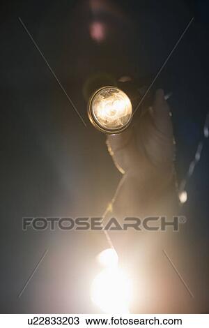 Stock Image - Hand holding flashlight. Fotosearch