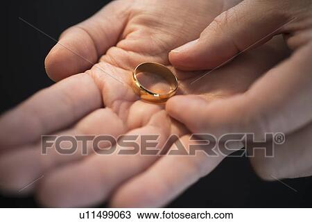Hand holding wedding ring View Large Photo Image Stock Image - Hand holding wedding ring. Fotosearch