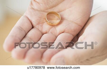 Hand holding wedding ring View Large Photo Image Stock Photo - Hand holding wedding ring. Fotosearch