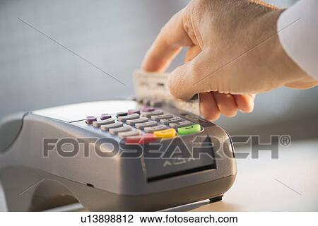 Stock Image - Hand paying with credit card. Fotosearch