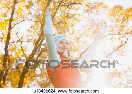 Picture - Happy young woman spinning in autumn forest. Fotosearch