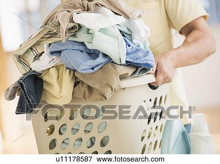Stock Photo - Man carrying laundry basket. Fotosearch