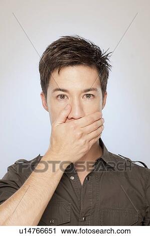Stock Image - Man covering his mouth. Fotosearch