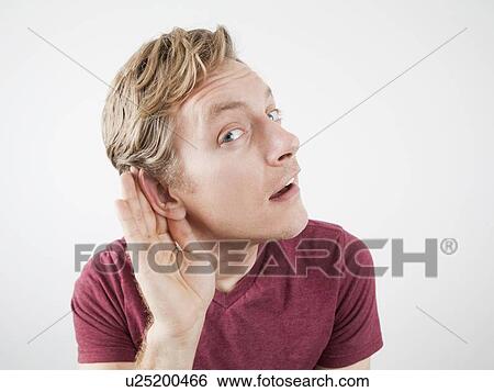 Stock Photograph - Man cupping his ear with his hand. Fotosearch