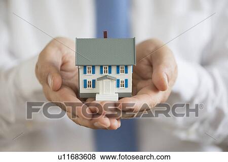Man holding model house View Large Photo Image Stock Photo - Man holding model house. Fotosearch