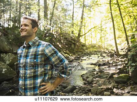 Man standing in forest View Large Photo Image Stock Photo - Man standing in forest. Fotosearch