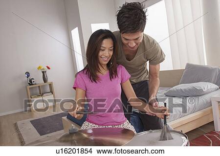 Picture - Man teaching woman how to play drums. Fotosearch