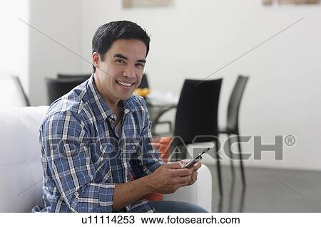 Man texting in living room View Large Photo Image Stock Image - Man texting in living room. Fotosearch