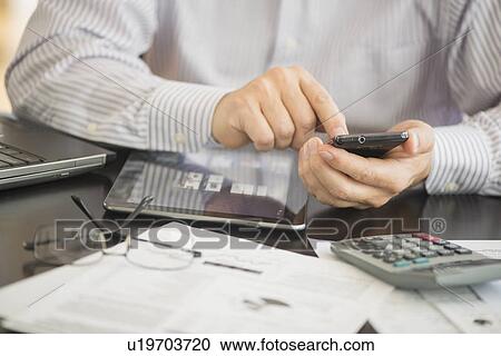 Stock Image - Man using tablet pc, laptop and smartphone. Fotosearch