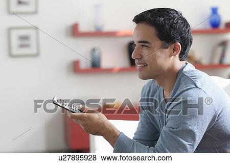 Man watching tv in living room View Large Photo Image Stock Photo - Man watching tv in living room. Fotosearch