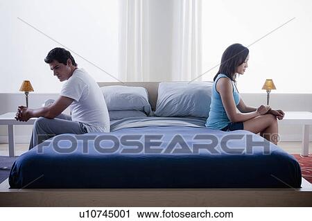 Mid adult couple after quarrel sitting on bed View Large Photo Image Stock Image - Mid adult couple after quarrel sitting on bed. Fotosearch
