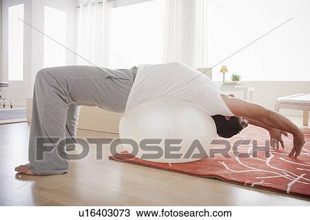 Mid adult men exercising with fitness ball View Large Photo Image Stock Image - Mid adult men exercising with fitness ball. Fotosearch