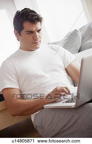 Mid adult men in pajamas using laptop View Large Photo Image Stock Image - Mid adult men in pajamas using laptop. Fotosearch