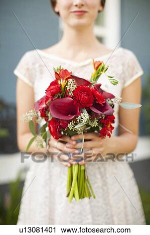 Stock Image - Mid section of bride with bouquet in focus. Fotosearch